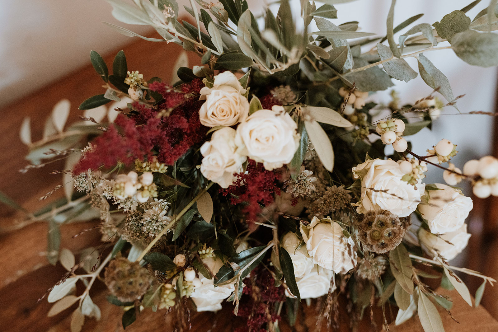 Allestimento floreale Boho chic con rose bianche, eucalipto, amaranto bordeaux,