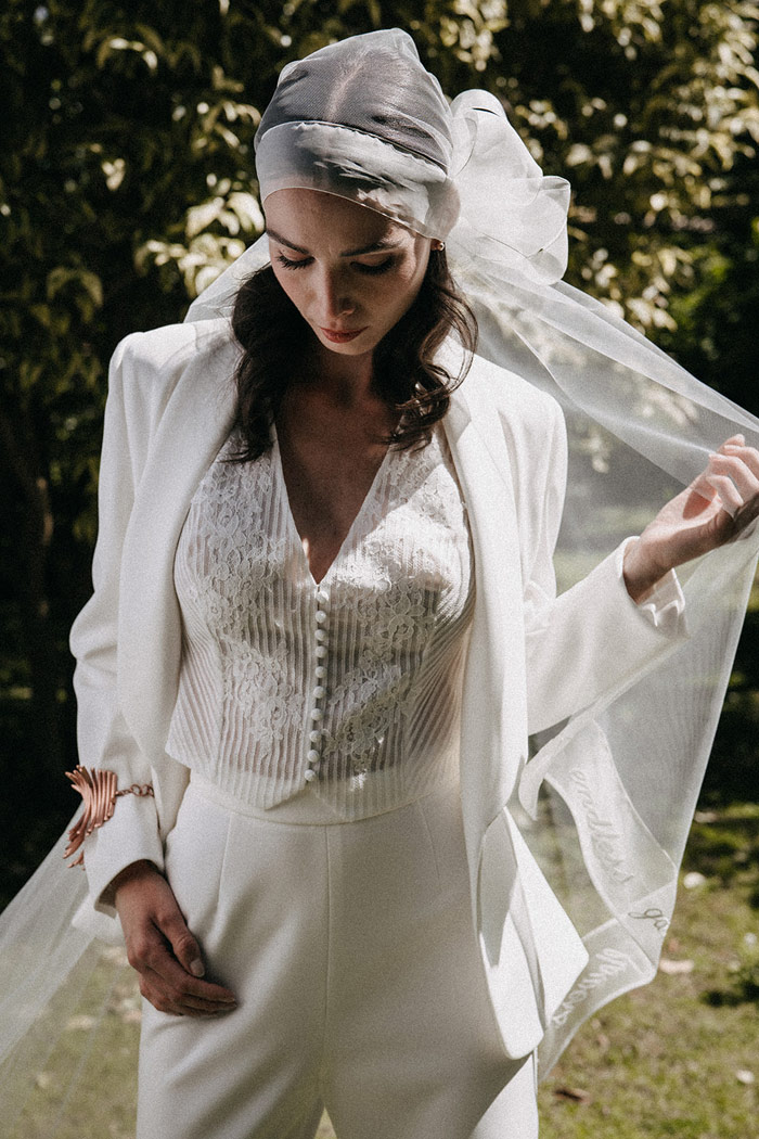 look-sposa-alternativo-con-gilet-in-pizzo-giacca-e-pantalone sposa con abito tre pezzi alternativo particolare composto da giacca gilet e pantalone con velo bordato in organza