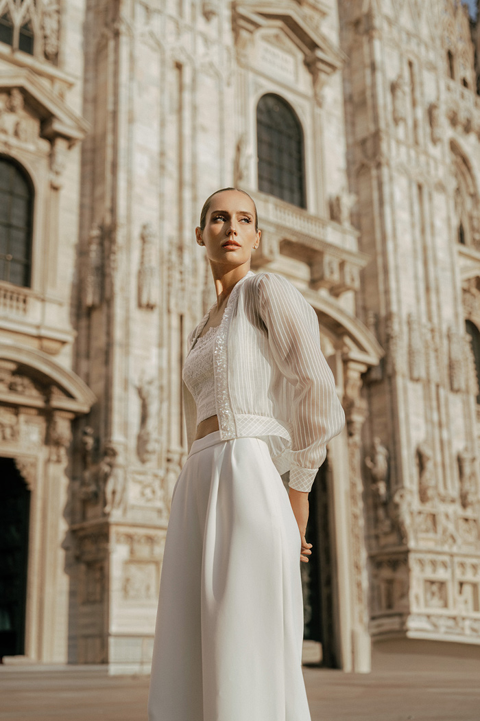 sposa-con-abito-due-pezzi-giacchino-e-pantalone-fotografata-davanti-al-duomo-di-milano sposa fotografata davanti al Duomo di Milano con abito sposa due pezzi top tuta pantalone