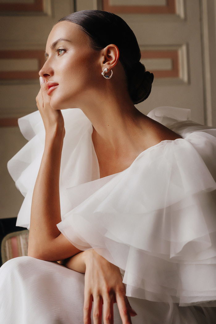 sposa-con-coprispalle-particolare-in-organza sposa elegante indossa vaporoso bolero in organza di seta fatto di volant