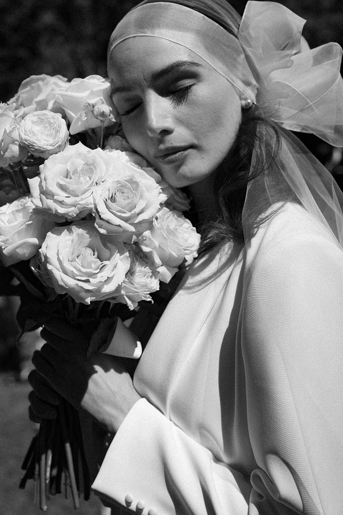 sposa-con-velo-bordo-in-organza-e-bouquet-di-rose-bianche sposa romantica con look particolare e bouquet di rose bianche