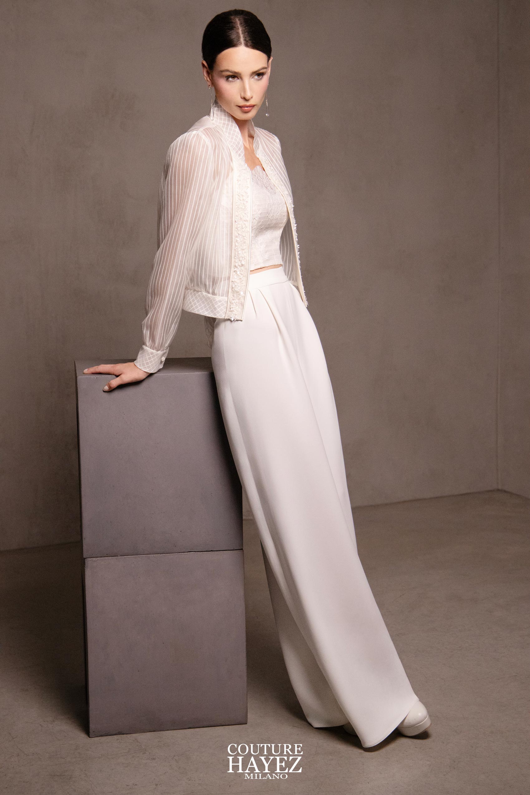 sposa indossa abito non convenzionale due pezzi pantalone palazzo, top e giacchino leggero in organza con maniche lunghe